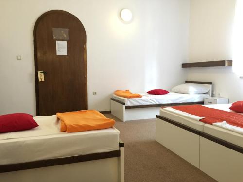 a room with two beds and a door in it at Pansion Ruža in Novi Vinodolski
