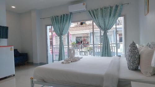 a bedroom with a large bed with a large window at Cinderella Residence in Patong Beach