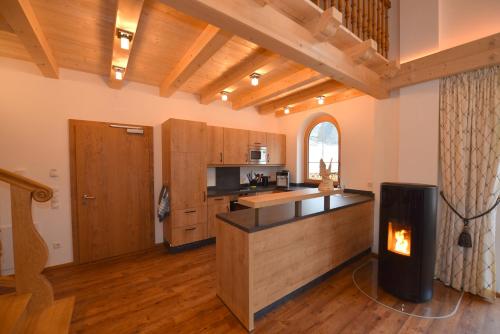 - une cuisine avec une cheminée au milieu d'une pièce dans l'établissement Krölls Alpenchalet, à Krimml