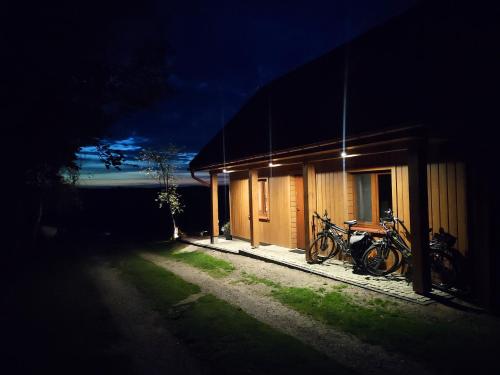 a group of bikes parked outside of a building at night at Dolina Biebrzy - Chata Flisaka in Wroceń
