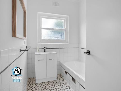 een witte badkamer met een bad en een wastafel bij Just Renovated in the Heart of Pt Elliot in Port Elliot