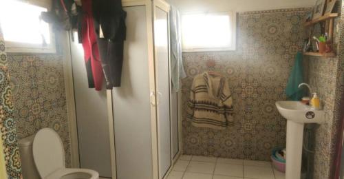 a bathroom with a shower and a toilet and a sink at Ait Mouli Surf House in Safi