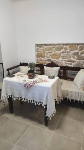 a table and chair in a room with a stone wall at Ανακαινισμένο Διαμέρισμα in Chios