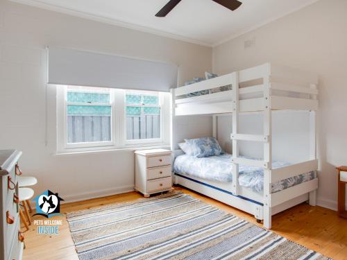 1 dormitorio con literas blancas y alfombra en Just Renovated in the Heart of Pt Elliot, en Port Elliot