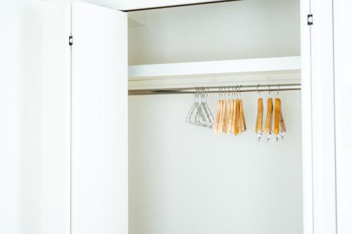 a closet with white doors and orange curtains at Smart Vacation Canaan A スマートバケーション　カナン A in Kagoshima