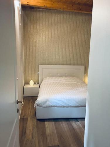 a bedroom with a white bed and a wooden floor at Loft Eburnea 13 in Perugia