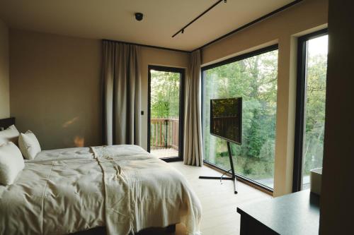a bedroom with a bed and a large window at Boutiquehotel DAS ZEITWERT in Deutschlandsberg
