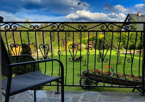 a wrought iron fence with a bench and a garden at Pensjonat u Ani in Zakopane