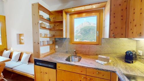 eine Küche mit einem Sofa, einem Waschbecken und einem Fenster in der Unterkunft Ers 52 in Pontresina