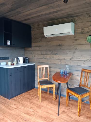 a kitchen with a table and two chairs and a table and a sink at Wild Meadow in Sēja