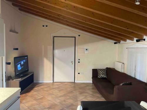 Una sala de estar con un sofá y un televisor. en La Meridiana, en Lonato