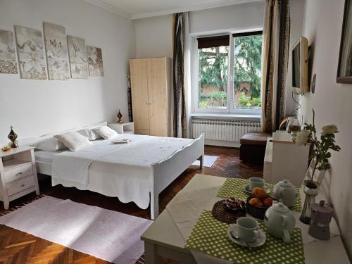 Dormitorio blanco con cama y mesa en Apartments Magnolija - Zagreb Centre, en Zagreb