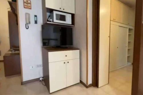a kitchen with a microwave and a white cabinet at Appartamento di Giulio & Giorgia in Predazzo