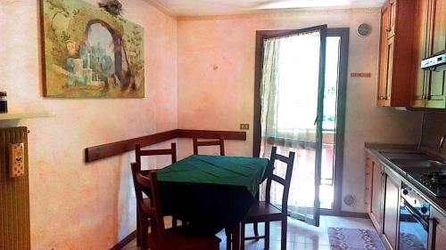 une cuisine avec une table et des chaises ainsi qu'une fenêtre dans l'établissement Appartamento di Giulio & Giorgia, à Predazzo
