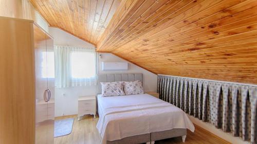 ein Schlafzimmer mit einem Bett und einer Holzdecke in der Unterkunft Tanaydın Evleri in Fethiye