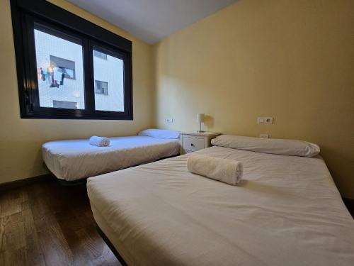 2 camas en una habitación con ventana en 1A106 Amplio y cómodo apartamento, en Gijón