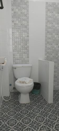 a bathroom with a toilet and a tile floor at AINNY Residence in Patong Beach