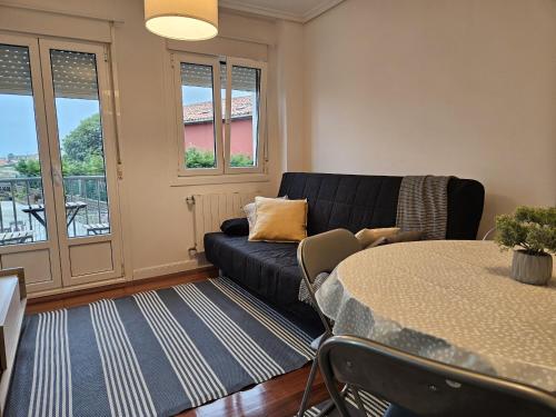 uma sala de estar com um sofá e uma mesa em C12A01 Coqueto apartamento con piscina y garaje em Suances