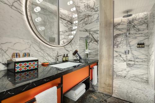 a bathroom with a sink and a mirror at Hotel Indigo Guangzhou Haixinsha by IHG - Free Shuttle Bus to Canton Fair Complex during Canton Fair period in Guangzhou