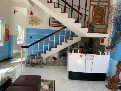 a staircase in a living room with a stair case at Thanh Tran Guesthouse Lý Sơn in Ly Son