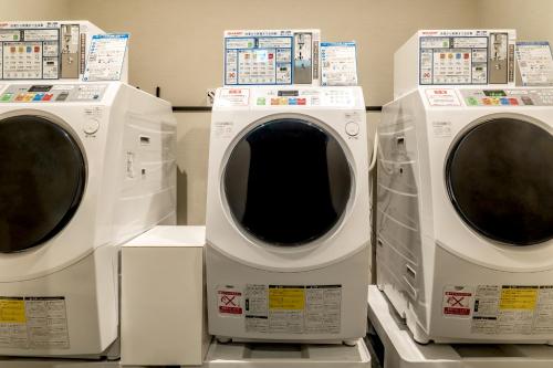 three washing machines are sitting next to each other at The Royal Park Canvas - Osaka Kitahama in Osaka