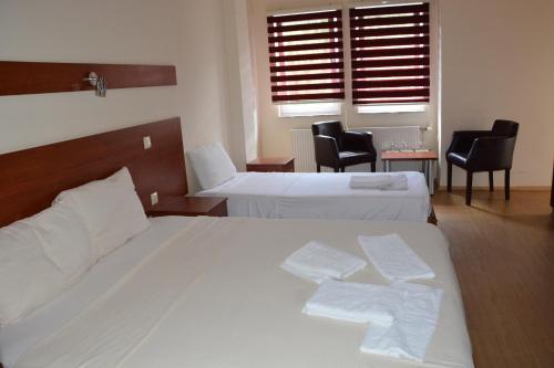 een hotelkamer met 2 bedden en 2 stoelen bij Arabella Hotel in Kičevo