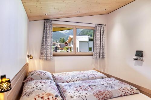 two beds in a room with a window at Gamsberg in Obernberg am Brenner