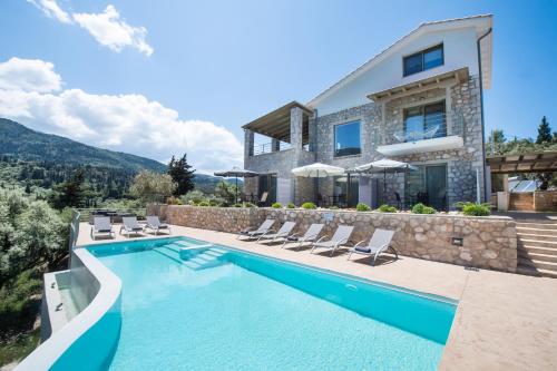 a villa with a swimming pool and a house at Mylos Mountain Villas- Villa Giorgio in Agios Nikitas