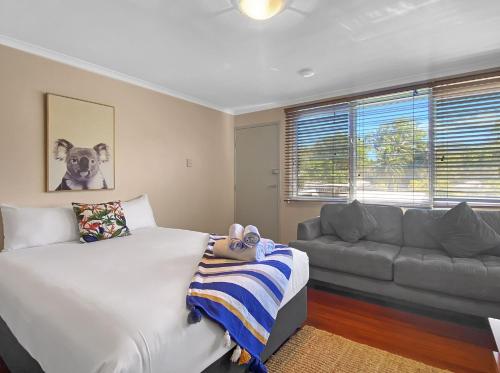 a bedroom with a bed and a couch at Picnic Bay Apartments Unit 4 in Picnic Bay