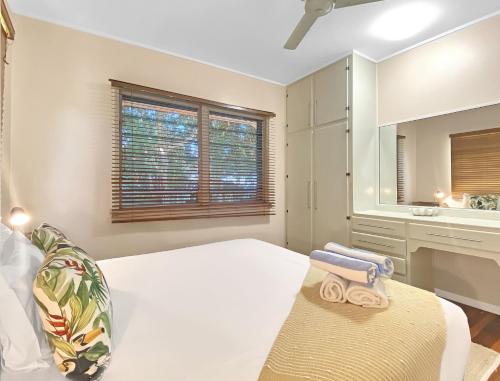 - une chambre blanche avec un lit et un lavabo dans l'établissement Picnic Bay Apartments Unit 4, à Picnic Bay