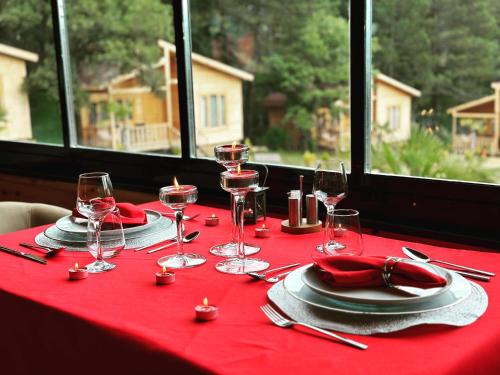 KORU AURA MENGEN في مِنغِن: طاولة مع قماش الطاولة الحمراء مع كؤوس النبيذ