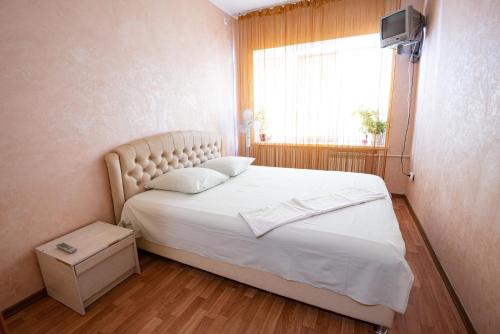 a bedroom with a large white bed with a window at Дашковича 30, центр міста in Cherkasy
