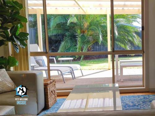 a living room with a couch and a large window at Coastal Vibe, 4 beds Short Walk to the Beach in Aldinga Beach