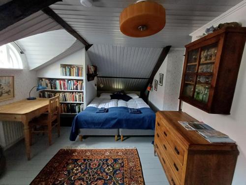 ein Schlafzimmer mit einem Bett und einem Schreibtisch in einem Zimmer in der Unterkunft Flodhästens Husrum & Frukost in Varberg