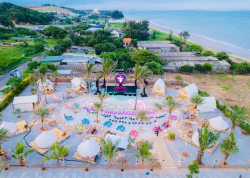 an aerial view of a resort with a pool and the ocean at Suly's Village Phan Thiết in Phan Thiet