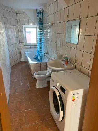 a bathroom with a toilet a sink and a washing machine at Monteurwohnung in Halle Saale in Halle an der Saale