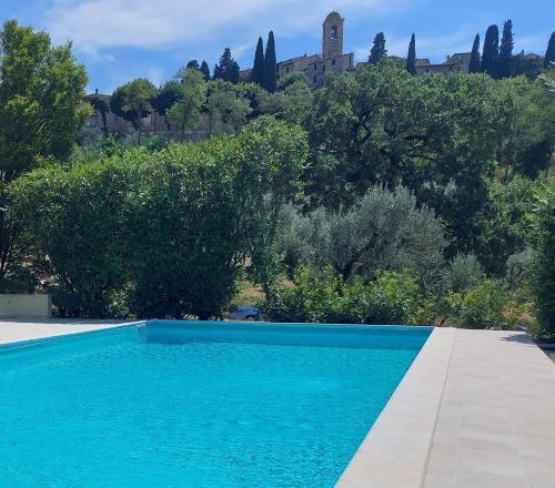 una piscina blu con un edificio sullo sfondo di La Selvarella a Montecchio