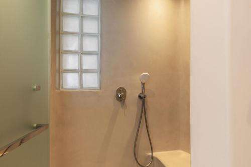 a shower in a bathroom with a window at Sunset Hill Suites in Mýkonos City