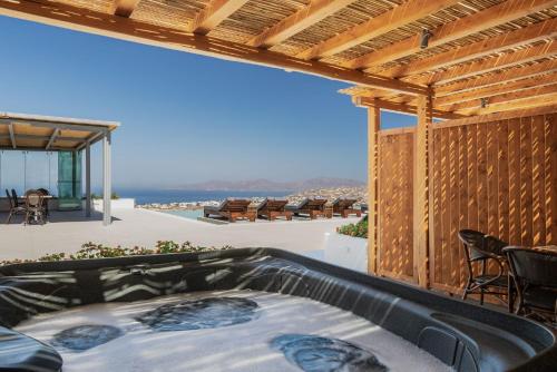 a hot tub on the patio of a house at Sunset Hill Suites in Mýkonos City