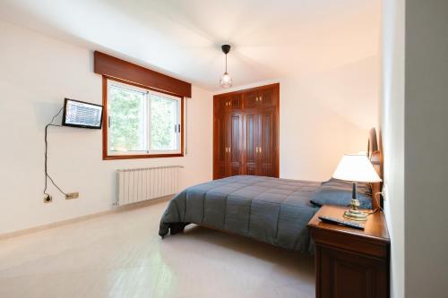 a bedroom with a bed and a desk and a window at Casa Bella Lalin- 4 Double bedroom Galician Country Home! in Pontevedra