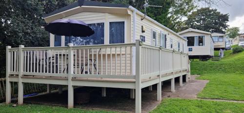 a large white house with an umbrella on the deck at A5 Avocet Rise in Paignton