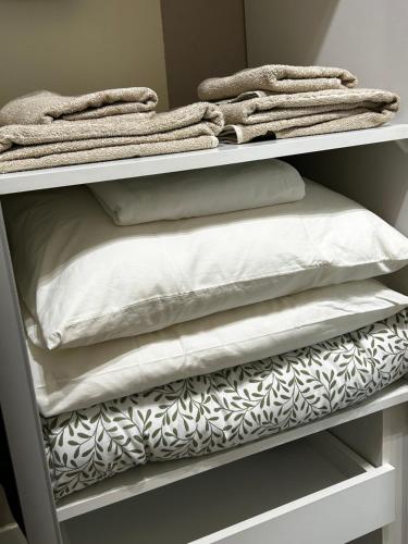 une étagère remplie d'oreillers et de couvertures blancs dans l'établissement Przytulne mieszkanko, à Białystok