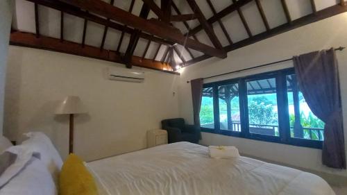 1 dormitorio con cama y ventana grande en Rumah Jepun, en Mataram