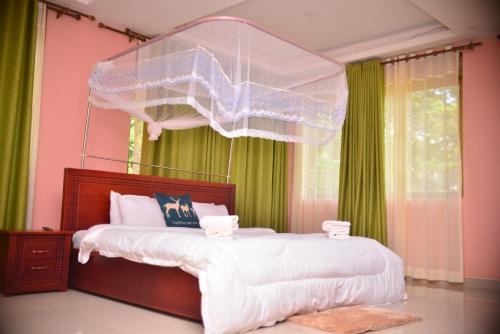 een slaapkamer met een groot bed met een net bij Elgon Palace Hotel - Mbale in Mbale