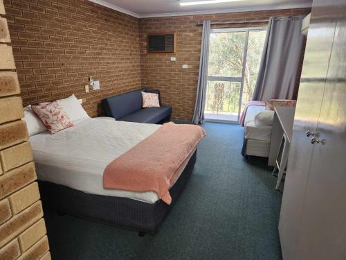 pokój hotelowy z łóżkiem i oknem w obiekcie Corowa Golf Club Motel w mieście Corowa