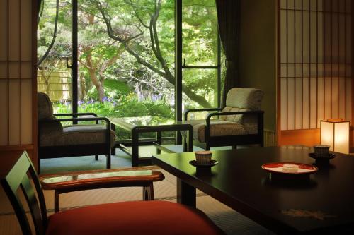 a room with a table and chairs and a window at Tachibanaya in Tsuruoka