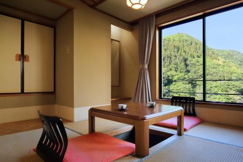 a room with a table and a large window at Tachibanaya in Tsuruoka