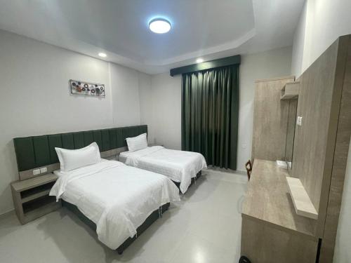 um quarto de hotel com duas camas e uma janela em ديار المشاعر للشقق المخدومة Diyar Al Mashaer For Serviced Apartments em Meca