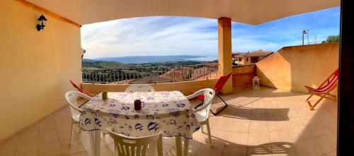 a table and chairs on a balcony with a view at Casa Smeralda - Piscina e vista sul Mare! in Trinità dʼAgultu