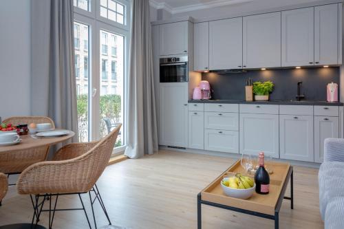 una cucina con armadi bianchi e un tavolo con un cesto di frutta di Steuerbord a Westerland
